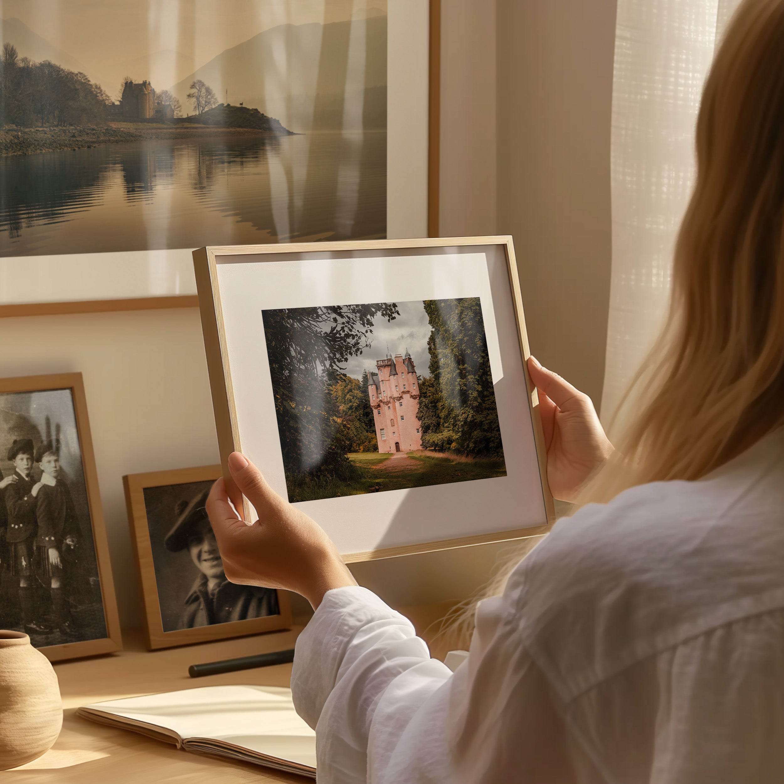 Frame held by a woman with a Scottish landscape photo print inside the frame.