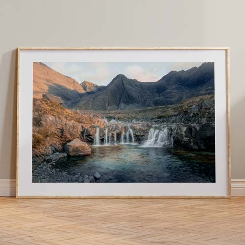 A landscape photograph print of a waterfall lining against a wall